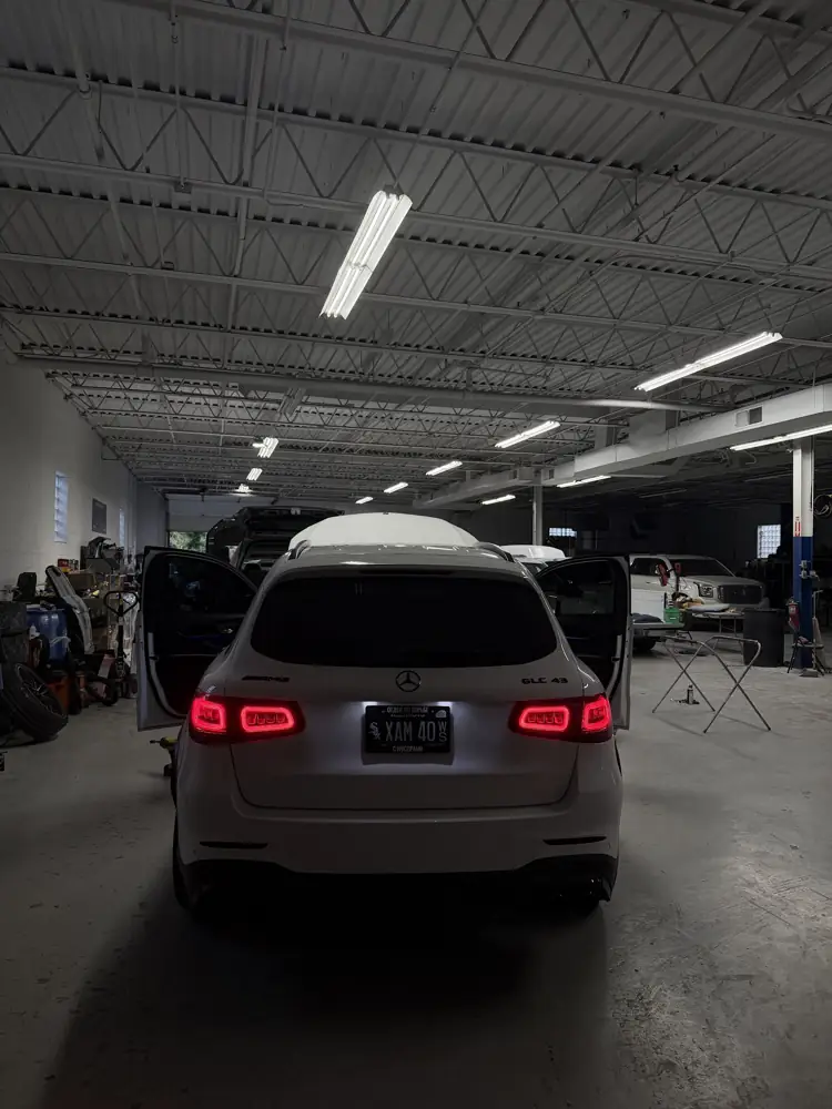White Mercedes SUV in the shop with the doors and hatch open